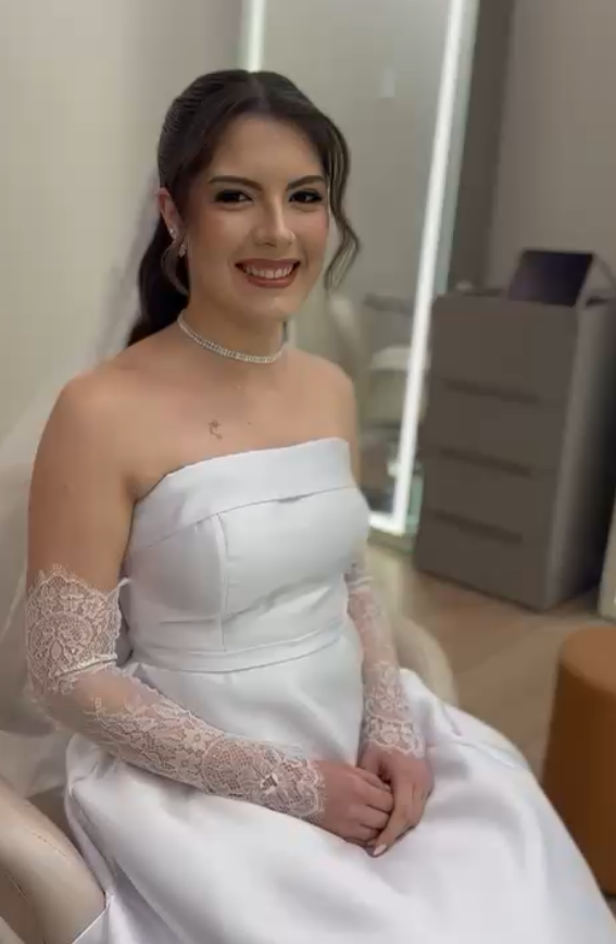 Noiva sentada, pronta, com vestido, luvas de renda e colar